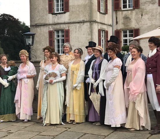 Gruppenbild der Tänzer in Kostümen vor dem Schloss