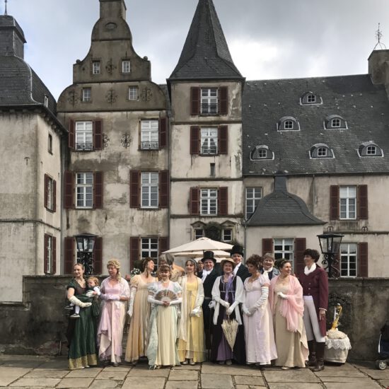 Gruppenbild der Tänzer in Kostümen vor dem Schloss