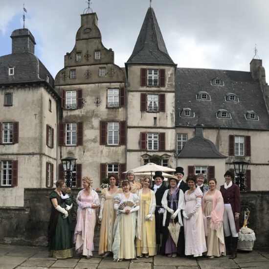 Gruppenbild der Tänzer in Kostümen vor dem Schloss